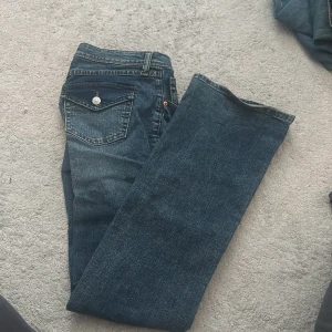 Mörkblå jeansbyxor med raka ben - Säljer ett par klassiska mörkblå jeans med bootcut ben och femficksmodell från HM. Använt kanske en gång. 