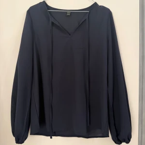 Mörkblå tunn blus  - Mörkblå tunn blus med en liten v ringad hals. Perfekt till sommaren när du vill ha något fint men enkelt.