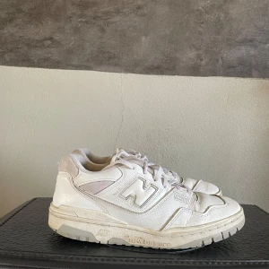 New Balance 550 - Säljer ett par vita New Balance 550 sneakers. De har en klassisk design med snörning och en bekväm passform. Perfekta för en stilren look. Storlek  44. Priset är inte hugget i sten!