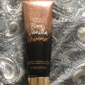 Bare Vanilla Shimmer Lotion från Victoria's Secret - En lyxig shimmer lotion från Victoria's Secret med doften Bare Vanilla. Den kommer i en glittrig förpackning med en kapacitet på 236 ml. Perfekt för att ge huden en skimrande finish och en härlig vaniljdoft!