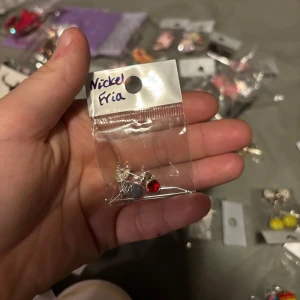 Nickelfria örhängen med röda och svarta stenar - Säljer ett par nickelfria örhängen med en röd och en svart sten. Perfekta för att ge en färgklick till din outfit. Kommer i en praktisk liten plastpåse.