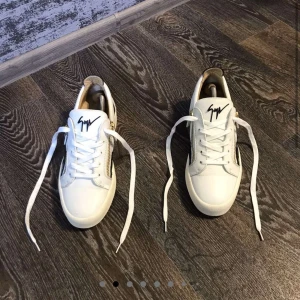 Giuseppe zanotti skor - Snygga vita sneakers med svarta sidopaneler och gulddetaljer. Skorna har snörning och dragkedja på sidan för extra stil och en perfekt look. Ett par tvär feta giuseppes i väldigt bra skick. Box ingår ej endast skorna följer med. Är öppen för byten!
