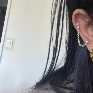 örhängen med kedjedetalj - Snygga silverörhängen med en kedjedetalj som hänger ner från örat. Perfekt för att ge en extra touch till din stil. Enkla men ändå iögonfallande!