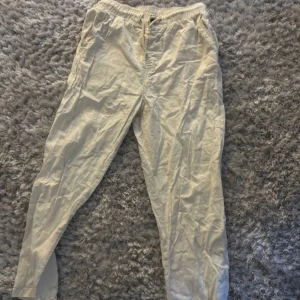 Beige linnebyxor med snörning - Säljer ett par bekväma beige linnebyxor med elastisk midja och snörning. Perfekta för en avslappnad stil. Byxorna har en lös passform och är tillverkade i ett lätt och luftigt material. Har använts lite men har inga defekter, hör av om ni har funderingar 