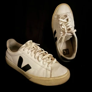 Vita skor från Veja - Säljer ett par stilrena vita sneakers från Veja med svarta detaljer. Skorna har en klassisk design med snörning och en bekväm passform. Perfekta för en avslappnad stil, och perfekta till sommaren. Skick 6/10. Säljer pågrund av att dem är för små, jag köpte skorna för nästan prick ett år sedan för 1700kr, och använde dem cirka ett halvår.