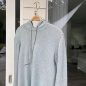 Ljusgrå hoodie - Säljer en stilren ljusgrå hoodie 100% cashmere. Perfekt för en avslappnad look. Tröjan har långa ärmar och är tillverkad i ett mjukt material. Passar riktigt bra till både jeans och mjukisbyxor 