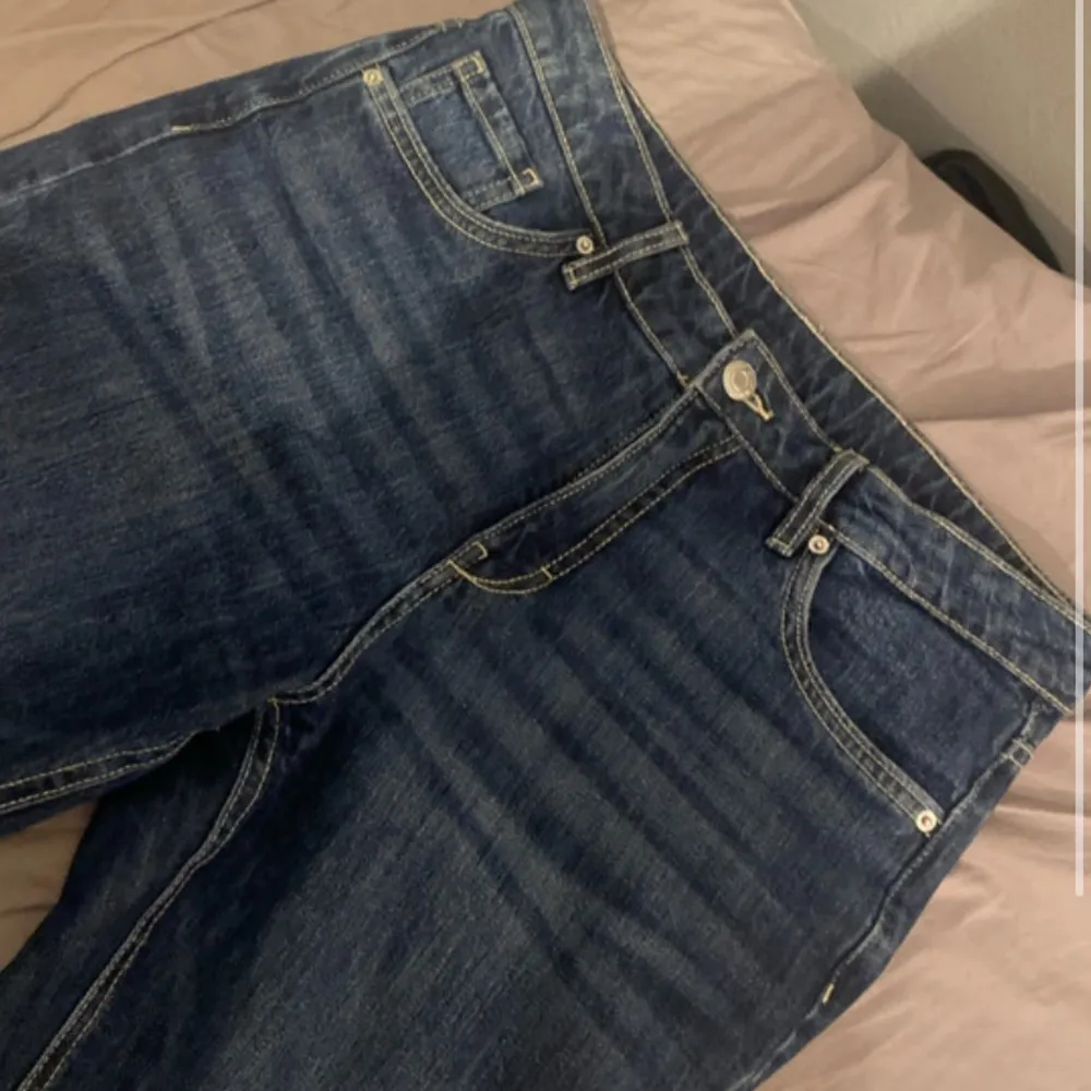 Snygga mörkblå jeans från Kappahl med klassisk femficksdesign och knappdetalj på bakfickan. Perfekta för en avslappnad stil.. Farkut & Housut.