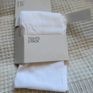 Vita strumpbyxor 1 st (säljer bara en av två tights) - Säljer ett 1 st vita strumpbyxor. Perfekta för att komplettera din outfit med en ren och klassisk look. Strumpbyxorna är mjuka och bekväma, idealiska för både vardag och speciella tillfällen.
