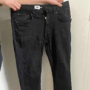 Svarta jeans från 157 - Snygga svarta jeans från 157 med dragkedja och knapp framtill. Klassisk femficksdesign och raka ben. Perfekta för en stilren look.