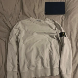 Stone island - Stone island i klassisk vit och är  100% äkta. För att bevisa att de är äkta så kan du scanna QR-koden som finns på en av bilderna.   Detaljer:  • Marke: Stone Island • Färg: Vit • Storlek:S • Skick: 10/10 • Material: Bekvamt och slitstarkt tyg Tröjans ikoniska Stone Island-kompasslogotyp på vänster ärm gör den igenkännbar och ger en exklusiv touch. Den är perfekt för bäde vardagsbruk och vardagliga tillfällen.