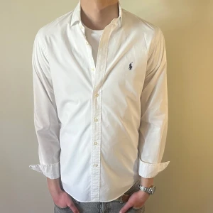 Vit Ralph Lauren skjorta - Nu säljer vi ännu en otroligt fet vita polo skjorta som passar till alla tillställningar! Du ska kunna uttrycka stil utan att det kostar för mycket!🕺🍾💼🤩  Storlek👔: M Nypris💰:  ca 1499 kr