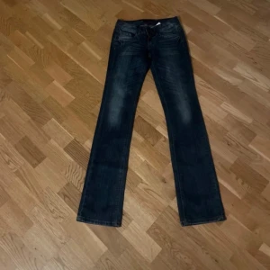 Mörkblå jeansbyxor - Snygga mörkblå jeansbyxor med en klassisk femficksdesign. Byxorna har en rak passform och är perfekta för en avslappnad stil. De har en diskret tvätt för en trendig look.