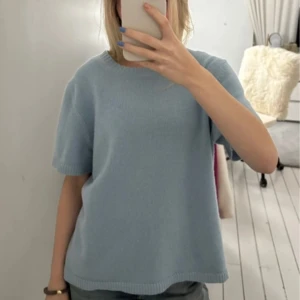 Ljusblå chunky T-shirt från Soft Goat - Säljer en ljusblå stickad tröja från Soft Goat i 100% kashmir. Tröjan har korta ärmar och en rund halsringning, perfekt för en avslappnad stil. Den är mjuk och bekväm, idealisk för både vår och sommar. Passar perfekt till jeans eller kjol för en casual look. Endast använd en gång så nyskick