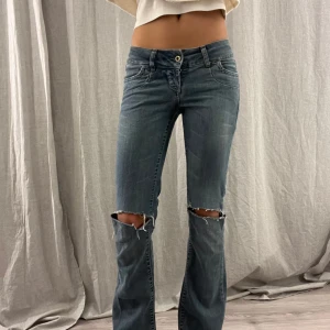 Lågmidjade jeans - Snygga blå jeans med slitningar, (ca!)>midjemått: 35cm, innerbenslängd: 80cm. Jag är 168 för referens. Lågmidjade och bootcut. Storleken är 25/32 och motsvarar ungefär XS 