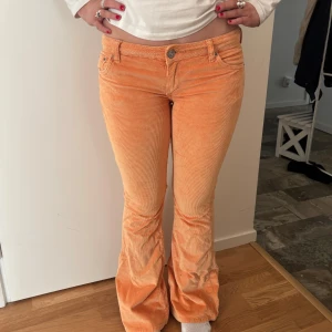Orange manchesterbyxor lågmidjade - Skitsnygga trendiga manchesterbyxor från BDG urban outfitters med bootcut och låg midja! Tyvärr är det för korta på mig som är 176, min vän på bilden är ca 169! Storleken är 26 och midjemåttet 76💕