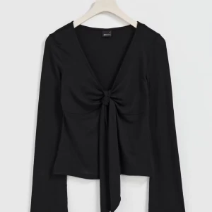 Svart långärmad topp från Gina Tricot - Snygg svart långärmad topp från Gina Tricot med knytning framtill. Perfekt för en stilren look. Tillverkad i ett mjukt och bekvämt material. I storlek xxs 