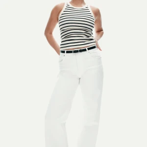 Randig croppad linnetopp från H&M - Säljer en vit och svart randig croppad linnetopp från H&M. Toppen har ribbad struktur och är ärmlös med breda axelband och rund halsringning. Perfekt till sommaren och enkel att matcha med jeans eller kjol.