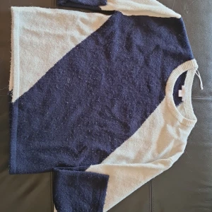 Blåvit stickad tröja från Gina Tricot - Säljer en stickad tröja från Gina Tricot i storlek 170. Tröjan har ett snyggt diagonalt mönster i mörkblått och vitt, med rund halsringning och långa ärmar. Perfekt för dig som gillar en enkel men stilren look.