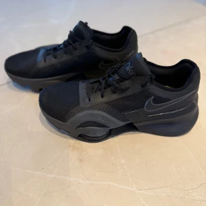 Nike sneakers  - Säljer ett par helsvarta Nike Air Zoom SuperRep 3. Skorna har en sportig design med rund tå, platt sula och tydlig Nike-logga på sidan. Perfekta för träning eller vardagsstil. I mycket bra skick. 