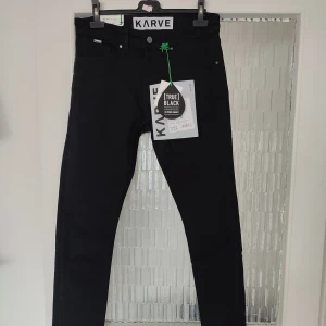 Svarta jeans från KARVE i storlek w28 - Svarta jeans från KARVE i storlek w28. Dessa jeans är i killmodell. Modellen på jeansen heter K MD Skinny True Black Swan. Gjorda med 71% ekologiskt bomull och 2% elastan. Helt nya med alla lappar kvar. Nypris på dessa är 699kr.