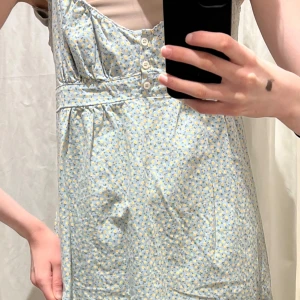 beige brandy klänning med blommor - Säljer den här supersöta beigea klänningen från Brandy Melville med gröna blommor. Det är samma modell av klänning som på första bilden men den exakta klänningen jag säljer är den beigea på bild 2-4. Klänningen har justerbara band och band i ryggen så man kan justera den efter sin kropp! Aldrig använd så i väldigt fint skick, så himla gullig till sommaren!💗