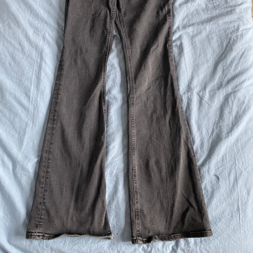 Säljer ett par gråa lager 157 jeans med bootcut passform. Jeansen har klassiska fem fickor, dragkedja och knapp framtill samt utsvängda ben. Perfekta för dig som gillar en retro vibe och vill ha något som sticker ut lite.. Farkut & Housut.