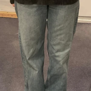Blåa raka jeans - Säljer ett par klassiska blå jeans med rak passform och hög midja. Jeansen har fem fickor och bälteshällor, perfekta för en avslappnad stil. Passar till det mesta och är ett måste i garderoben.