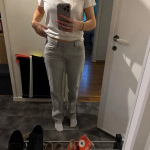 Ljusgrå jeansbyxor - Säljer ett par ljusgrå jeansbyxor med klassisk femficksdesign och raka ben. Byxorna har normal passform och är midwaist. Knappt använda, från Gina tricot 