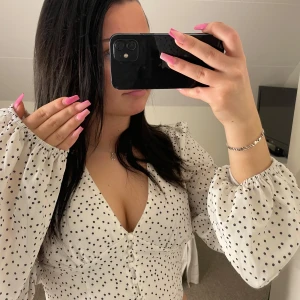 Vit prickig topp med puffärmar - Supersöt prickig topp/blus med v-ringning. 