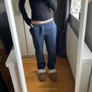 Blå mjukisbyxor med dragsko - Säljer ett par blå mjukisbyxor med normal passform och dragsko i midjan. Byxorna har raka ben och är tillverkade i mjukt bomullsmaterial, perfekta för en avslappnad stil.