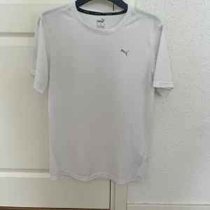 Vit tränings-tshirt från Puma - Vit t-shirt från Puma med diskret logga på bröstet. Tillverkad i lätt och ventilerande polyester med Dry Cell-teknologi. Klassisk passform och korta ärmar, perfekt för träning eller sportiga dagar. PRIS KAN DISKUTERAS!