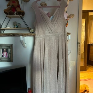 Glittrig champagnefärgad långklänning - Snygg långklänning från Goddiva London i champagnefärg med glittrigt tyg. Aldrig använt. Nypris mellan 700-900kr