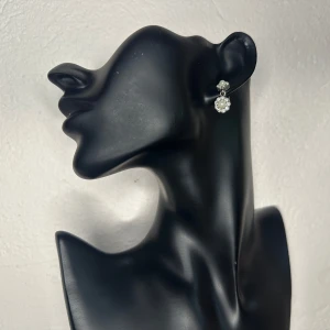 Vintageörhängen i 50-talsstil med pärla & strass Retro Old Hollywood  - Eleganta örhängen i vintagestil med silverfärgad metall, droppformad pärla och små glittrande strasstenar. Troligen från 50-/60-tal, men med stiftfäste vilket gör dem lättburna. Ca 2,5 cm långa – perfekta som romantisk detalj till vardag eller fest. Inköpta second hand, i mycket fint skick.  Prutning accepteras inte, men jag erbjuder gärna bundlerabatt. Kika gärna på mina andra annonser också!  ⸻  