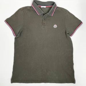 Moncler piké - Moncler piké i oliv. Perfekt plagg för alla tillfällen. L sitter som M. Skick: 8/10. Retail: 3,900 SEK. 
