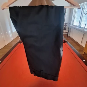 Dressman Kostymbyxor - Ett par riktigt stilrena kostymbyxor från dressman i bra skick, är svarta och perfekta för formella eller casual tillfällen. Kontakta gärna om funderingar!