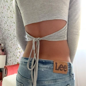 Grå topp med öppen rygg - Säljer en ljusgrå croppad långärmad topp med öppen rygg och snygg knytning bak. Vet ej märket. 💖💖