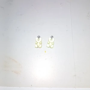 Vita björngodis örhängen - Söta örhängen formade som vita gelébjörnar. De har en glansig yta och är perfekta för dig som gillar roliga och unika accessoarer. Passar till dig som vill sticka ut med ett lekfullt smycke.