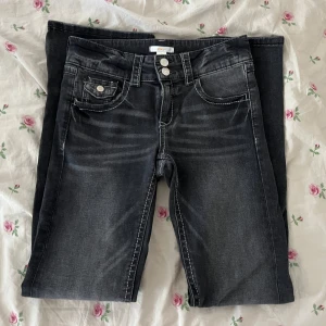 flared jeans - säljer ett par mörkgråa lågmidjade flared jeans från gina tricot young i storlek 164. endast testade, fortfarande i fint skick