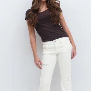 Vita straight jeans med slitningar - Snygga vita jeans med raka ben och diskreta slitningar vid knäna. Byxorna har klassiska fem fickor, silverfärgade knappar och bakfickor med lock. Perfekta för en clean och fräsch look. Säljer då dom är lite korta storlek 158💕