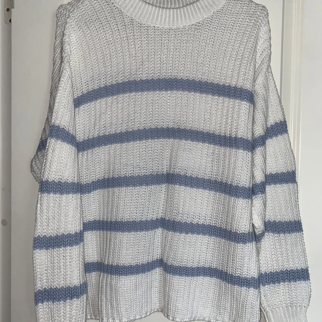 Vit stickad tröja med blå ränder