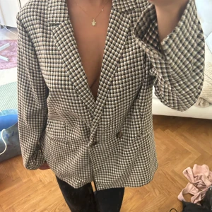 Rutig kavaj med knappar - Säljer en otroligt fin kavaj/ kappa som passar till alla typer av tillställningar. Kan stylas hur som!! 