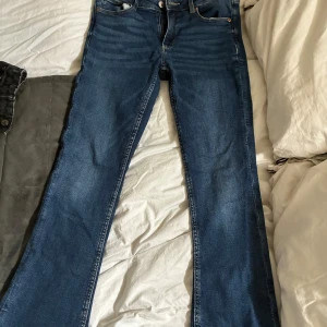Bootcut jeans - Säljer ett par klassiska jeans i blå denim. Modellen har bootcut-ben och femficksdesign med snygga kontrastsömmar. Bootcut modell