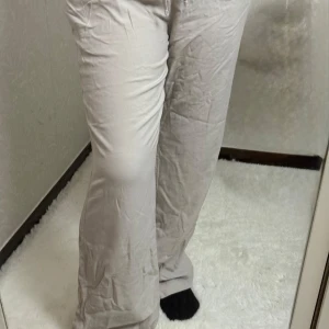 Beiga vida linnebyxor med snörning - Säljer ett par beiga linnebyxor med breda ben och avslappnad passform. Byxorna har snörning i midjan och sidfickor samt bakficka, perfekta för en chill och stilren look. Lätta och luftiga, passar grymt till sommaren.