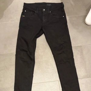 Tiger of Sweden jeans w29 - Ett par svarta tiger of Sweden jeans. W29 L34 Slim fit, men sitter rätt så tajt. Går att vika in byxbenen lite grann för en skönare känsla. Jeansen har använts <10 ggr och är nästan sprillans nya. Dem är väldigt moderna och trendiga, och det ikoniska mönstret på bakfickorna gör bara jeansen bättre