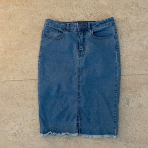 Jeanskjol  - Jätte snygg blå jeanskjol som är använd några få gånger. Den har en liten slits på framsidan och fransar längs kanten. Kjolen slutar ungefär lite över knäna. Storlek S men kan passa M då den är ganska stretchig.