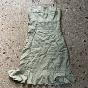 Ljusgrön linneklänning med volang - Söt ljusgrön klänning i linne med smala axelband och volangkant nertill. Figurnära passform och enkel design som känns fräsch och somrig. Säljs inte längre🫶