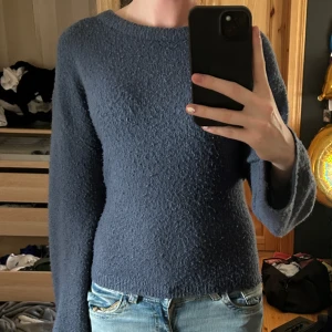 Blå stickad tröja från 157 - Mysig blå stickad tröja från 157 i storlek XS. Tröjan har en enkel, rund halsringning och långa ärmar. Materialet är fluffigt och ger en avslappnad vibe, perfekt till jeans. Snygg basic som funkar året runt.