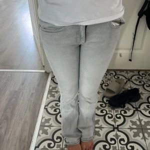 Ljusgrå bootcut jeans - Snygga ljusgrå jeans med bootcut passform och låg midja. Jeansen har klassiska fem fickor och är tillverkade i mjukt denimtyg. Perfekta för en chill och trendig look.