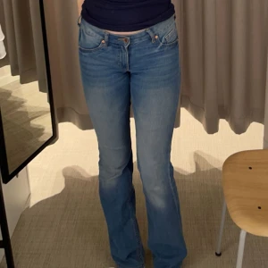 Blå bootcut jeans - Säljer dessa blå lågmidjade jeansen från HM i storlek 32 då de blivit för små för mig💕 De är i skönt material som inte är jobbigt att ha på sig och de är ganska långa i benen
