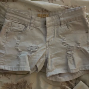 Vita lågmidjade jeansshorts - Snygga vita low waist denimshorts från Miss RJ med slitna detaljer framtill. Inga defekter. Skriv ifall du har frågor eller vill ha mer bilder💕